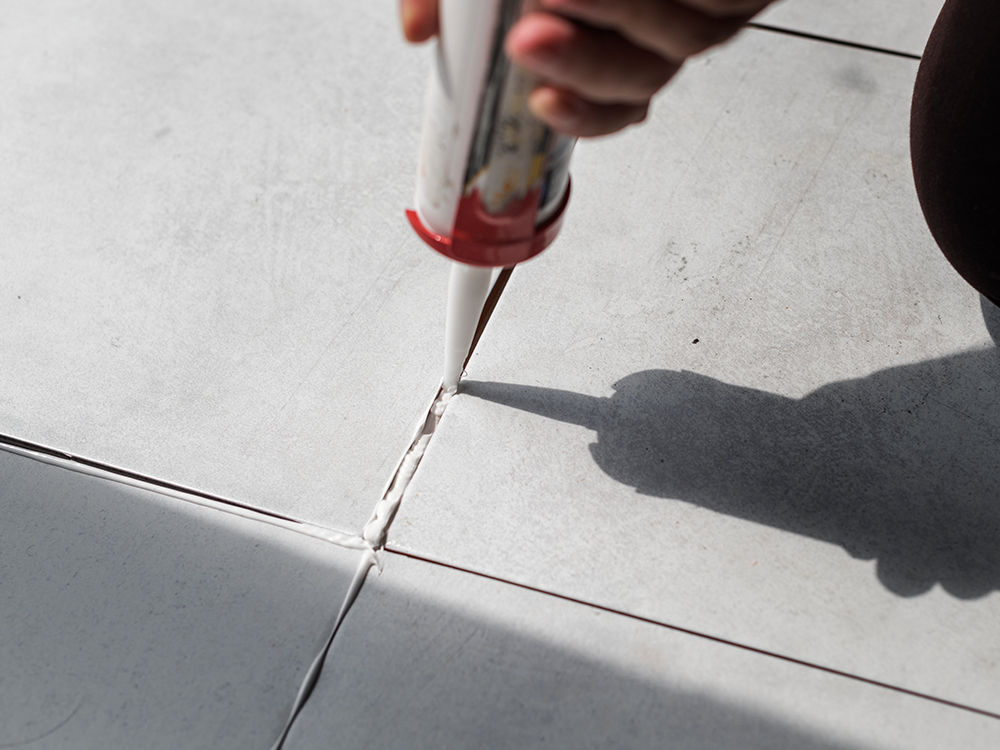 Tile adhesive being applied with a notched trowel